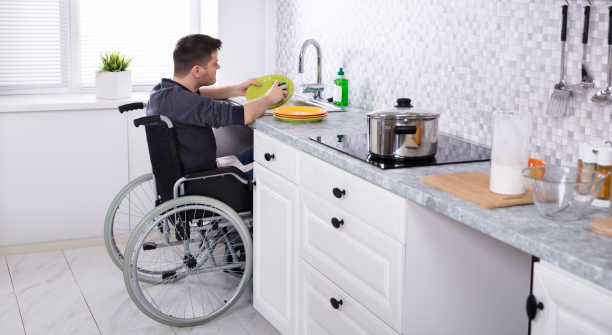man in a wheelchair washing dishes